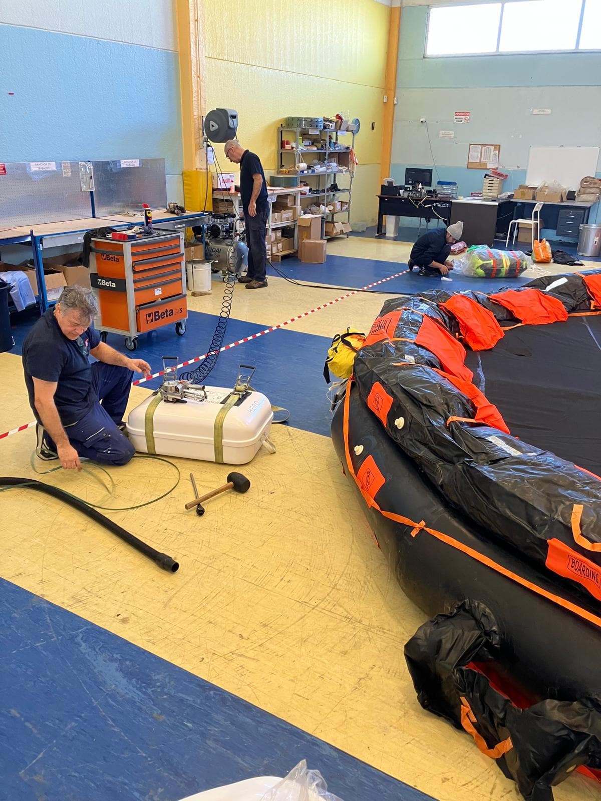 Técnico a ensaiar a pressão de uma balsa salva-vidas insuflada na estação de serviço